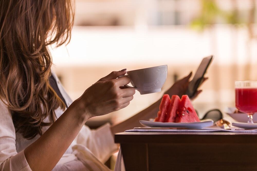 Vogal Luxury Beach Hotel & Spa Natal Exterior photo A woman drinking coffee